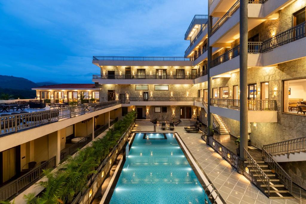 an apartment building with a swimming pool at night at Turban The Fort Resort & Spa, Kumbhalgarh in Kumbhalgarh