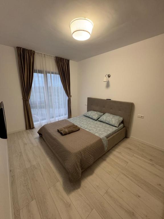 a bedroom with a bed and a large window at Apartament in Ploiești 6 in Ploieşti