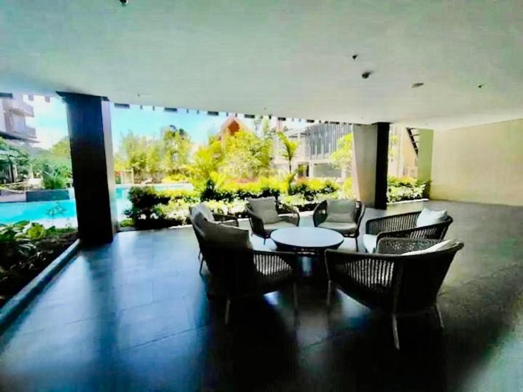 a patio with chairs and a table and a pool at Messatiera Condo - UrbanSol Stay in Davao City