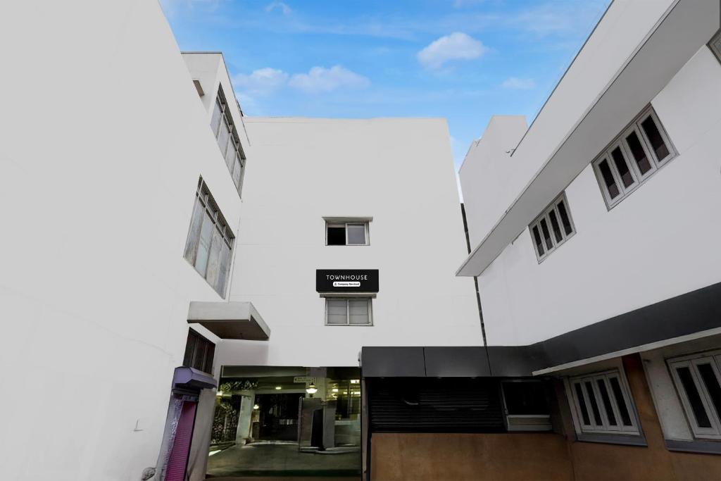 an external view of a white building at Super Townhouse Arcot Road Near Kauvery hospital in Chennai