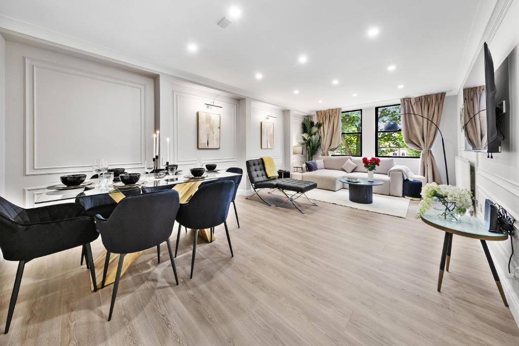 a living room with a table and chairs and a couch at The Queensborough Apartments by Hyde Park in London