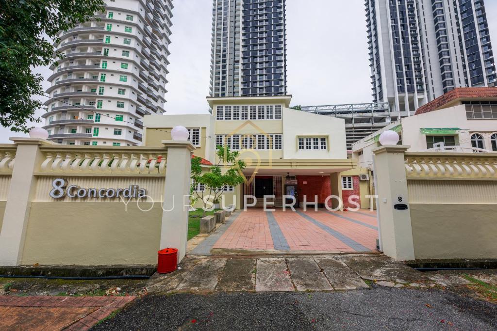 a building with a fence in front of tall buildings at 8 Concordia by YourSuperHost in George Town