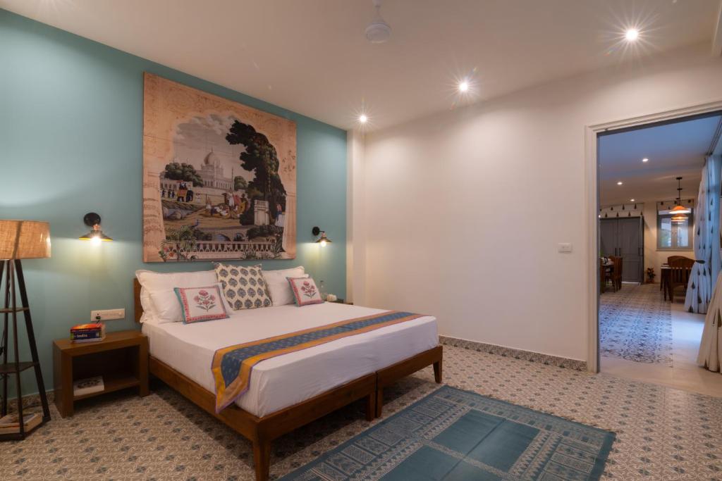 a bedroom with a bed and a painting on the wall at Inara House in Agra