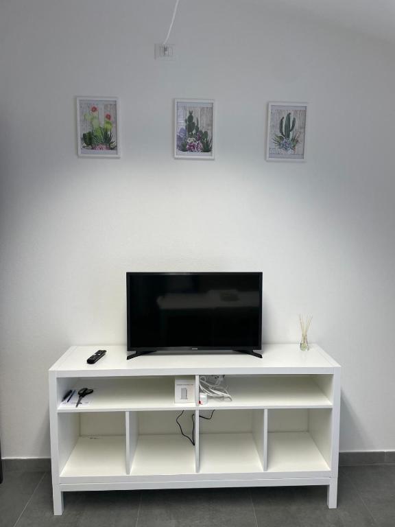 a white entertainment center with a flat screen tv on it at L&C hideaway in Sestu