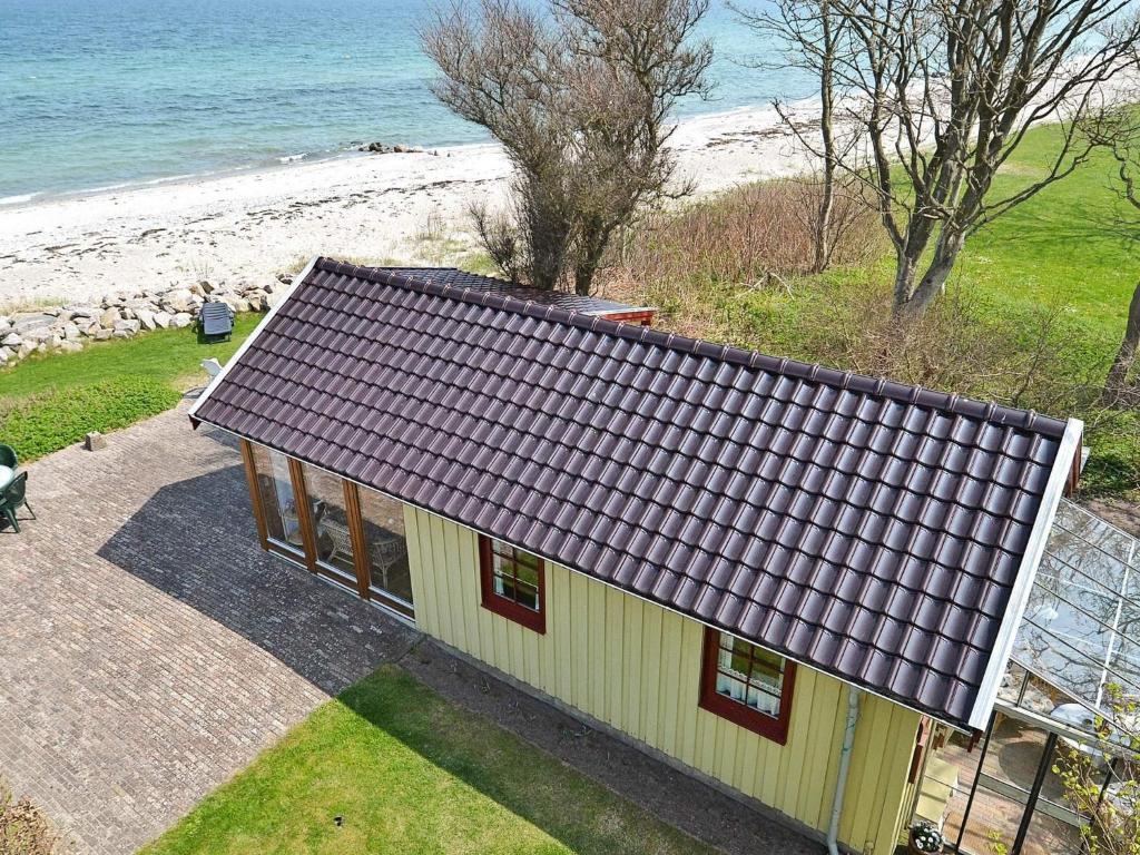 a house with a purple roof next to the beach at Seaside Panorama Escape - By Traum Ferienwohnungen in Otterup