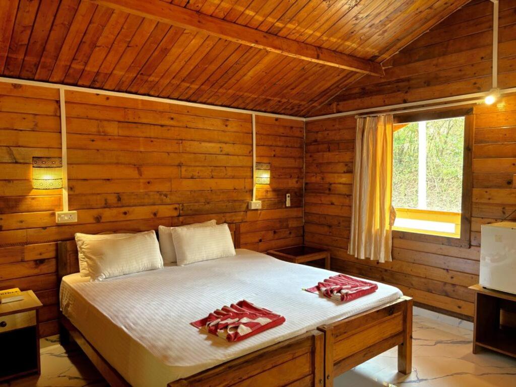 Un dormitorio con una cama en una cabaña de madera. en DEER COTTAGES Agonda, en Agonda