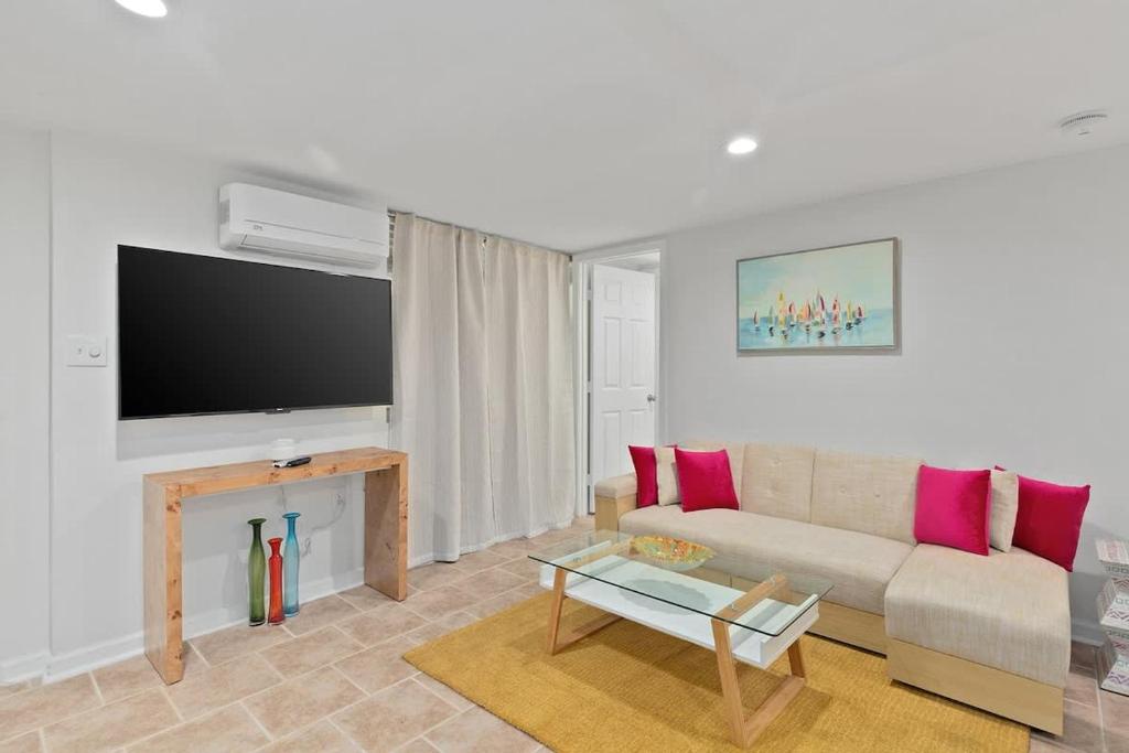 a living room with a couch and a tv at Elegant Private Basement Apartment with Full Kitchen & Living Room in Atlanta