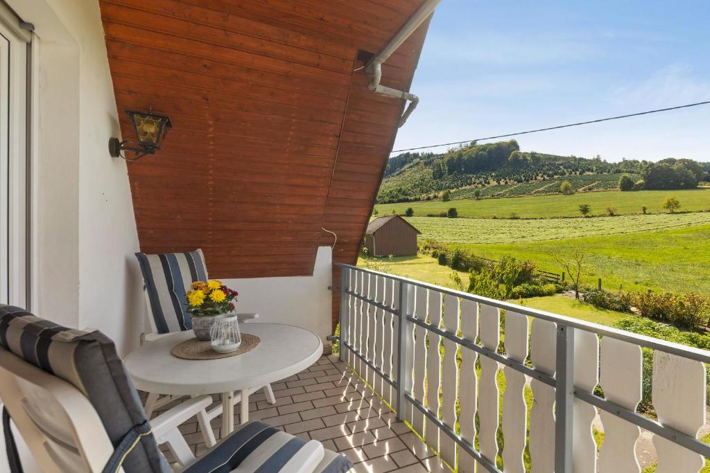 Un balcón con mesa y sillas y una vista en Ferienwohnung Wallensiepen, en Schmallenberg