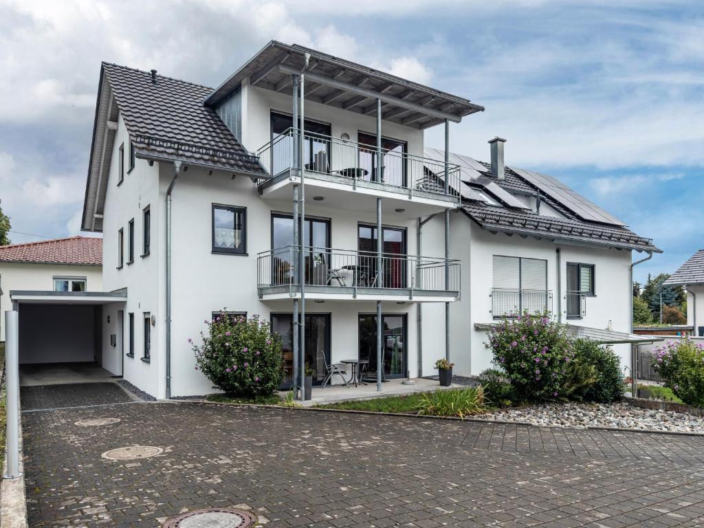 a white house with a black roof at Ferienhaus Am Kurpark in Bad Waldsee