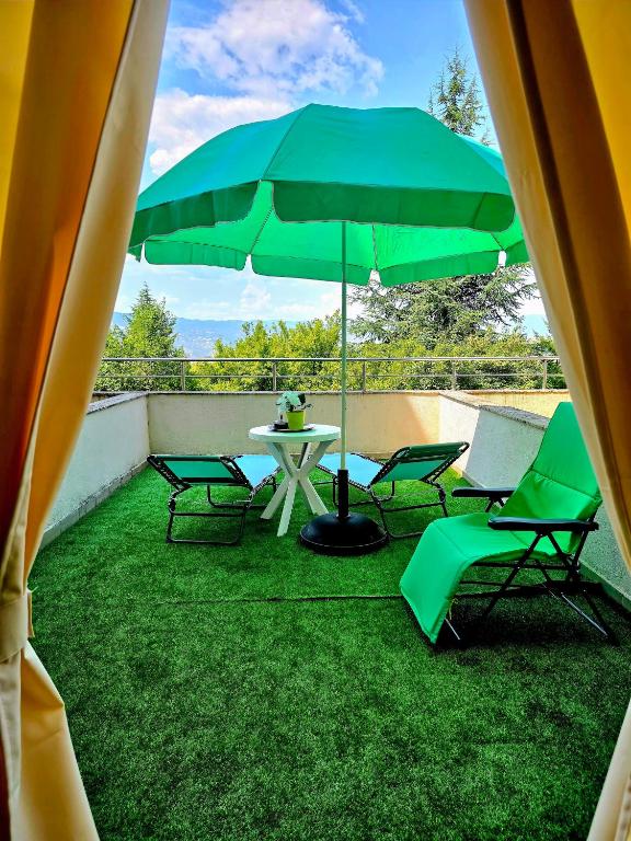 a patio with a table and chairs and an umbrella at Апартамент- Студио Кокетно in Sandanski