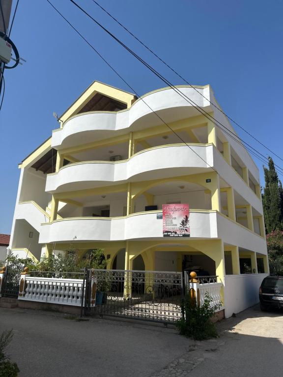 a white building with a sign in front of it at Villa Imperio in Ulcinj