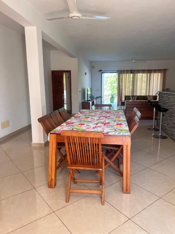 a dining room with a table with wooden chairs and a tableablish at Appartement OASIS in Hell-Ville