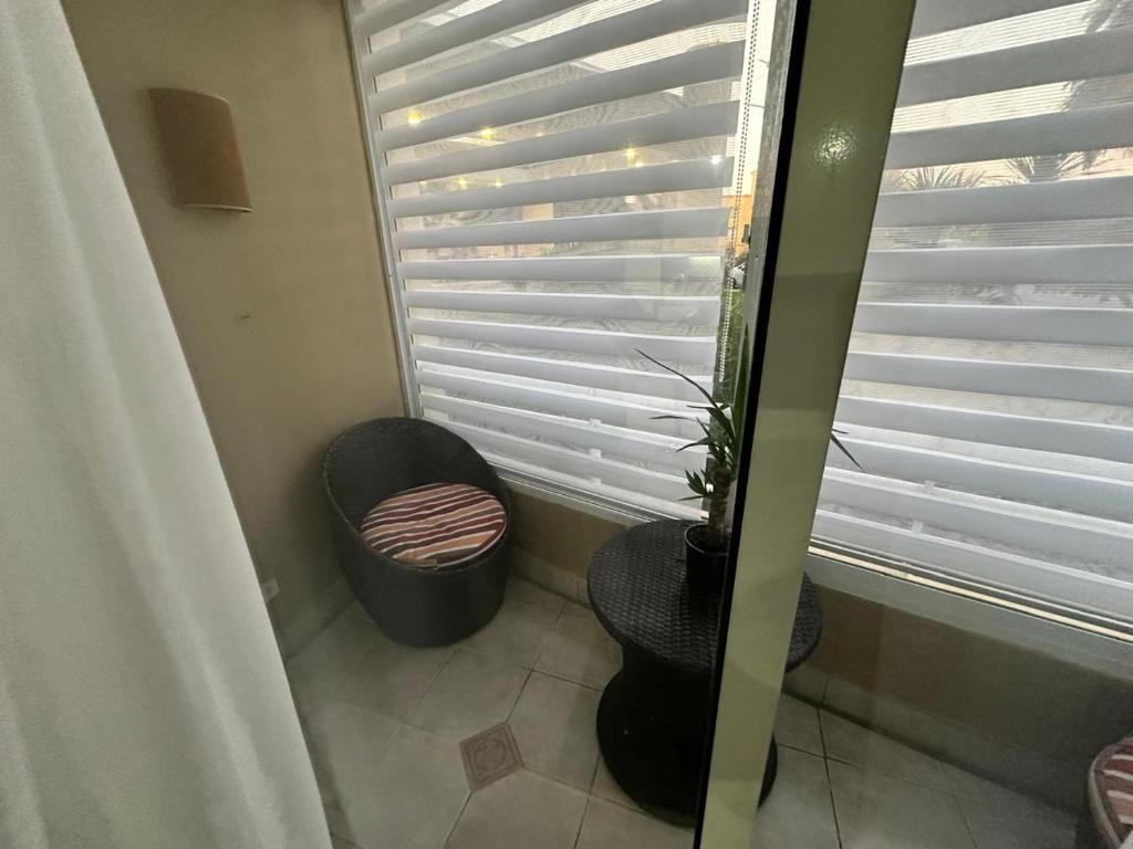 a room with a chair and a window with blinds at Departamento Full Equipado in Concón