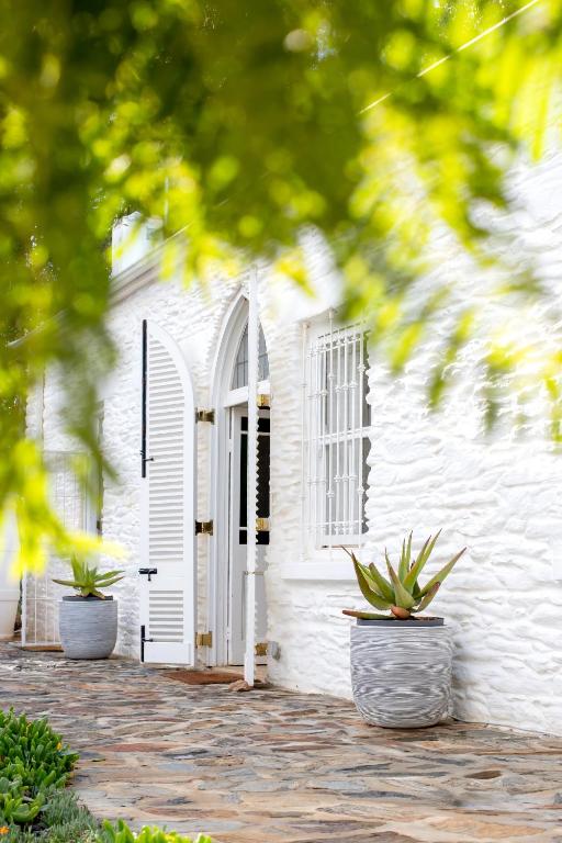 a white building with two potted plants in front of it at White House Koringberg in Koringberg