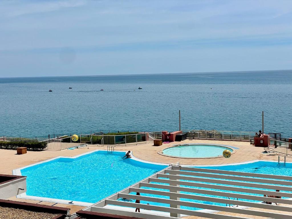 two large swimming pools in front of the ocean at ''578'' Superbe T2 Front de mer, Parking, Clim in Sète