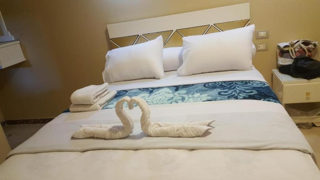 two swans made out of towels sitting on a bed at mariam guest house in Abu Simbel