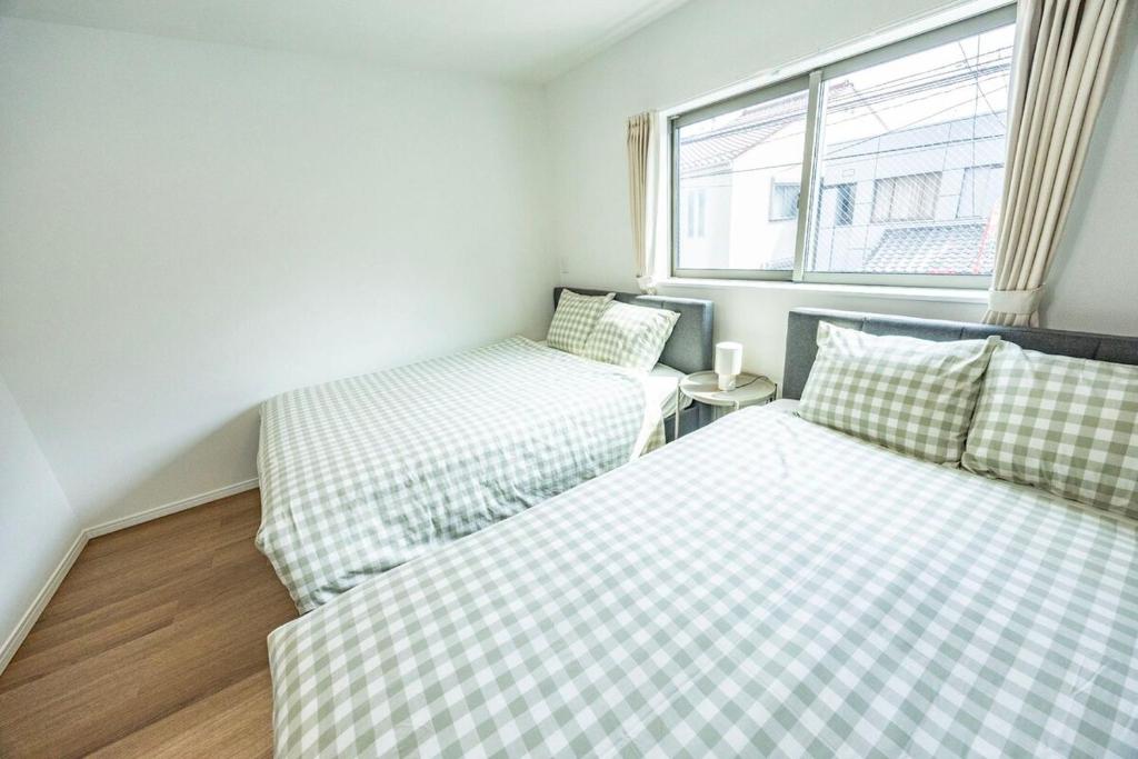 Un dormitorio con dos camas y una ventana. en Hiro Yanaka hotel, en Tokio