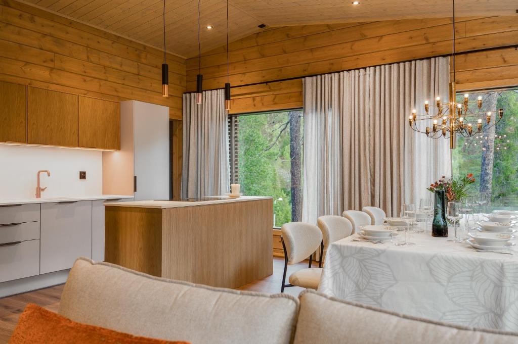 a kitchen and dining room with a table and chairs at Aurora B Luxury Lodge in Kuusamo