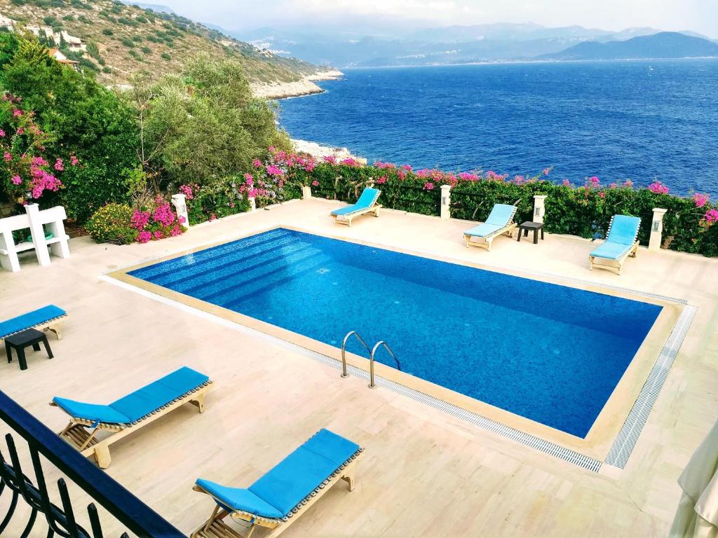 a swimming pool with chairs and a view of the ocean at Villa Escalade III in Kas