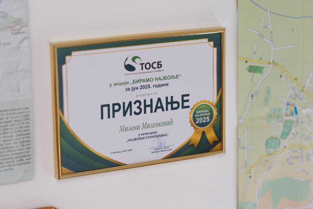 a framed sign on a wall next to a map at Smestaj Dzentlmen in Soko Banja
