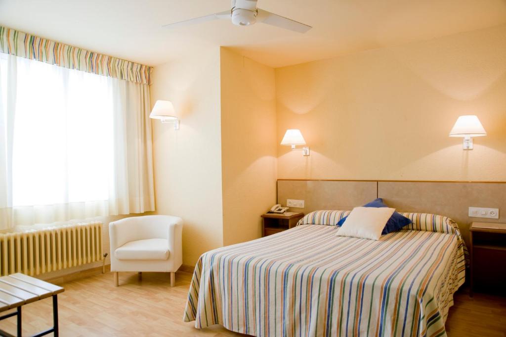 a hotel room with a bed and a chair at Hotel Balaguer in Balaguer