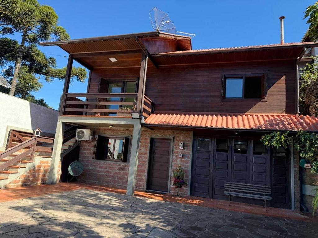 a house with a porch and a garage at Sua Casa no Centro Gramado, 1km Rua Coberta in Gramado