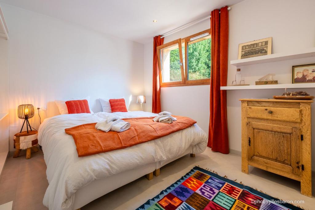 a bedroom with a bed and a window at Maison Outhera - Chambre d'hôtes in Orcières