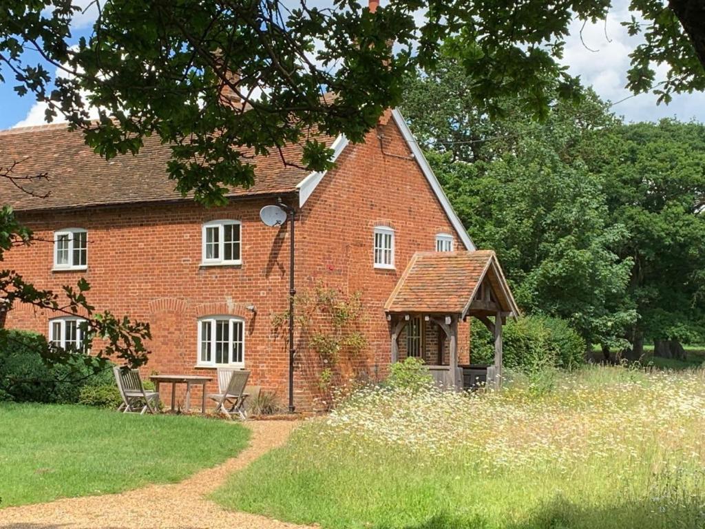 a red brick house with a gazebo at Boot Cottage in Sudbourne
