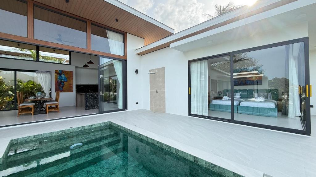 a house with a swimming pool and a bedroom at Suan Serenity Villa in Koh Samui