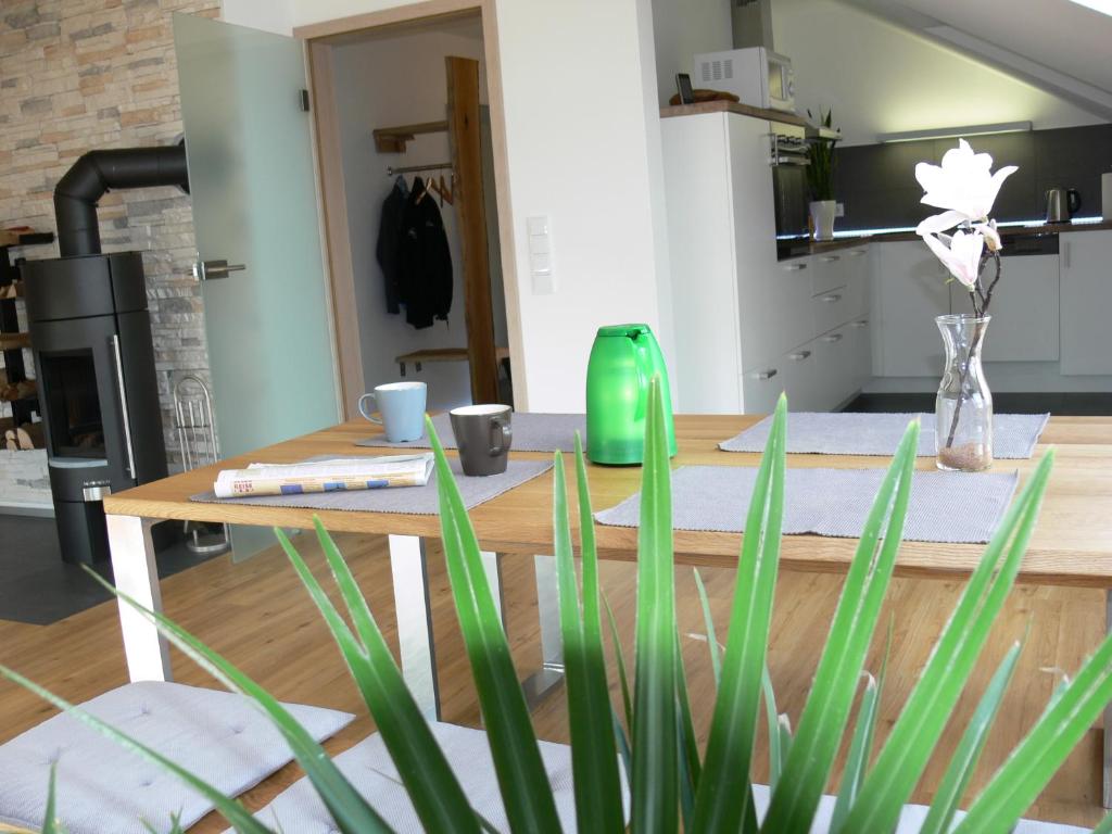eine Küche mit einem Tisch und einer grünen Vase in der Unterkunft Premium Ferienloft Dreßler Fulda in Fulda