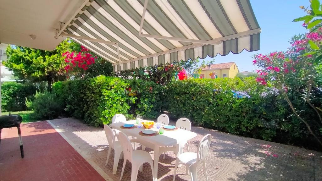 a white table and chairs under a pergola at Appartamento trilocale cod 462 in Marcelli