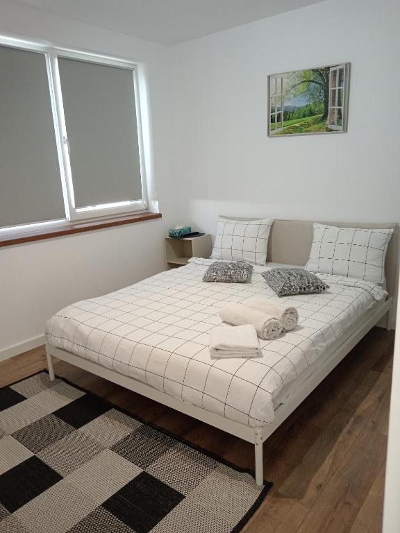a white bed in a room with a window at Zen aeroport in Sînnicoară