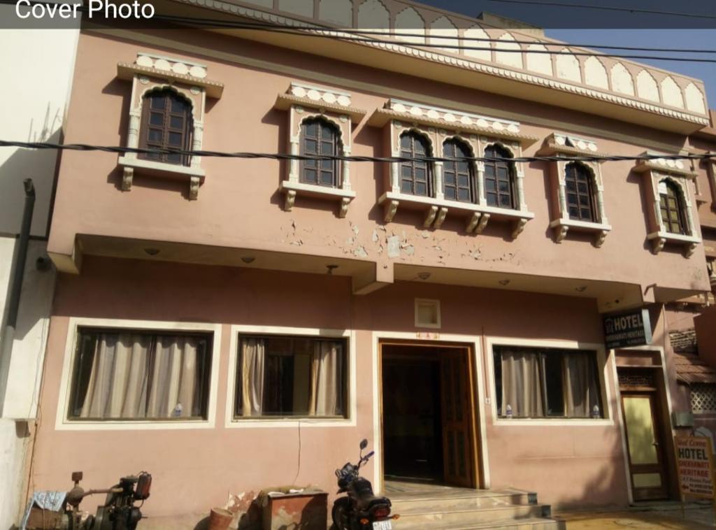una casa rosa con una moto parcheggiata di fronte di Shekhawati heritage a Jhunjhunūn