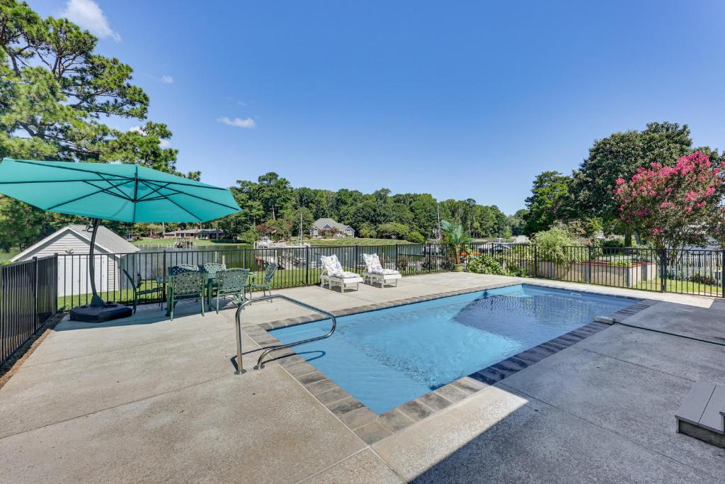 - Piscina con sombrilla, sillas y mesa en Historic Waterfront Home with Dock in Reedville!, en Reedville