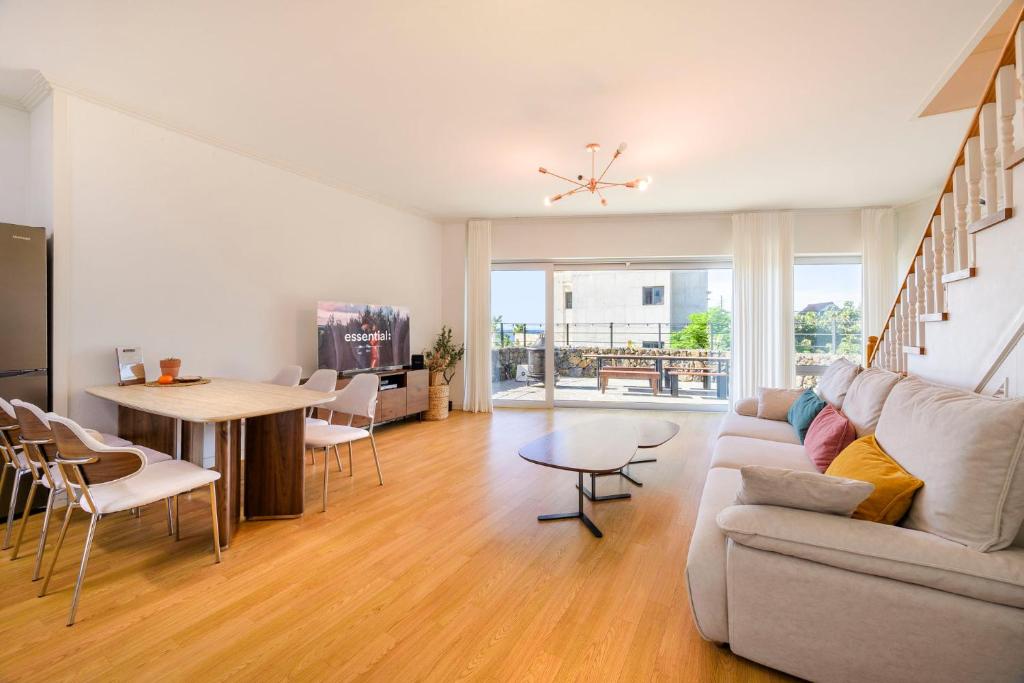 a living room with a couch and a table at Hold in Hamdeok with beach in Jeju