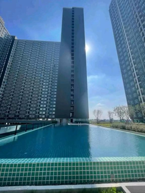 a swimming pool in front of a tall building at "Life city 1" Apartment 300 meters from BTS in Bang Chak