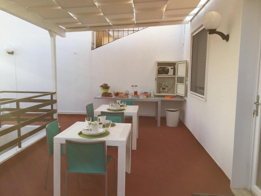 トッレ・ラピッロにあるSmile Affittacamereのテーブルと椅子2脚、キッチンが備わる客室です。