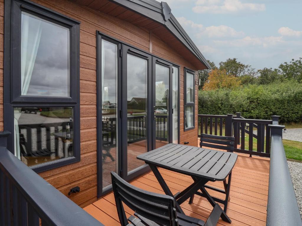 a wooden deck with a table and chairs on a house at Meadows Park 1 in Hull