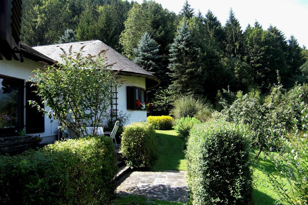 ein Haus mit einem Garten mit Büschen und Bäumen in der Unterkunft Ferienwohnung Monika in Bad Ischl