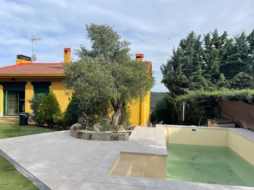 a yellow house with a swimming pool in a yard at La Casa del Lago in Mesones