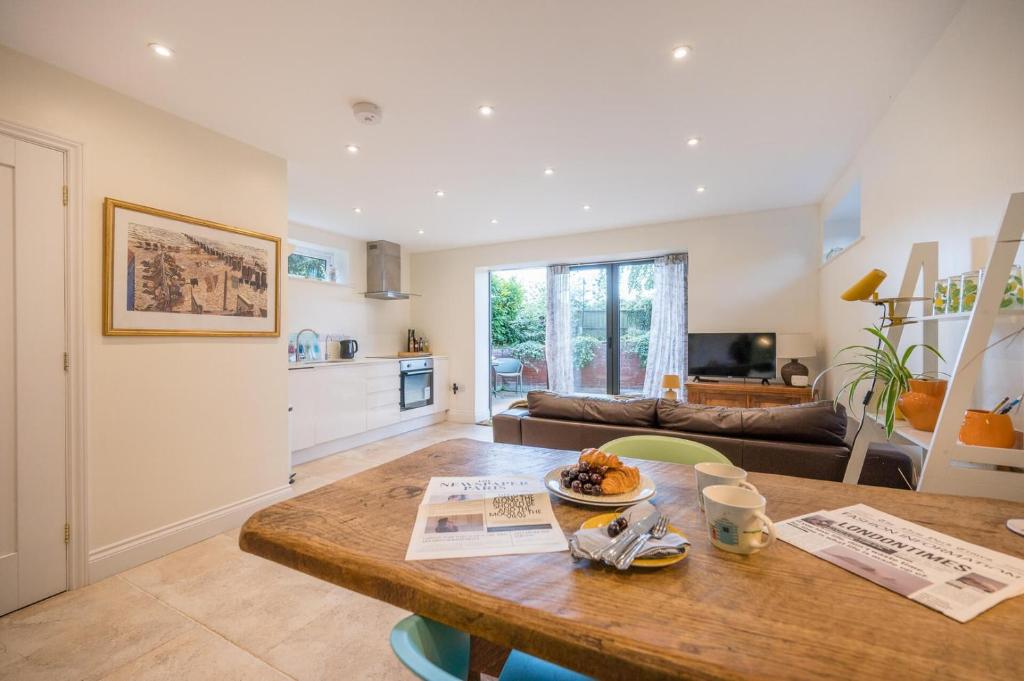 a kitchen and living room with a wooden table at Sedge Cottage "Barn", Reydon in Reydon