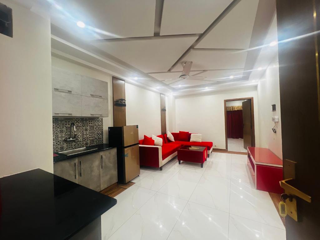 イスラマバードにあるRoyal Innのキッチン、リビングルーム(赤いソファ付)
