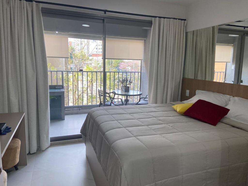 une chambre avec un grand lit et un balcon dans l'établissement Zampier Studio Moema, à São Paulo