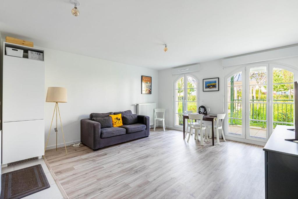 una sala de estar con un sofá y una mesa en GuestReady - Charming getaway near Disneyland, en Marne-la-Vallée