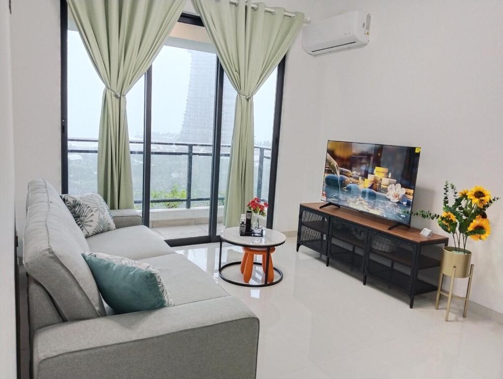 a living room with a couch and a flat screen tv at Holiday Home at Forest City with TV Box & 3 Bedrooms 1 Bathroom 4-6pax 1618 in Gelang Patah