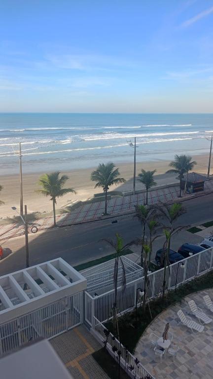 a view of a beach with palm trees and the ocean at Ocean View JJ in Mongaguá