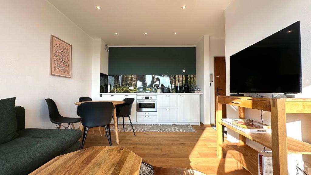 a living room with a couch and a table with a television at Loipenteufel - Zentral modern & am Lift mit Garage in Winterberg