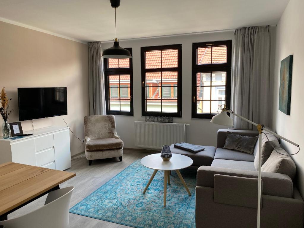 a living room with a couch and a table at discovAIXR - Super Zentral mit Parkplatz, Küche, Netflix und mehr in Eisenach