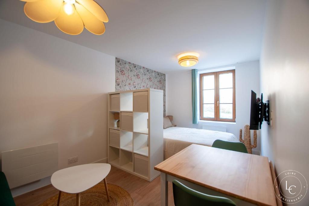 a bedroom with a bed and a table and a desk at Le Blois Apartment Modern comfort near the Loire castles in Courbouzon