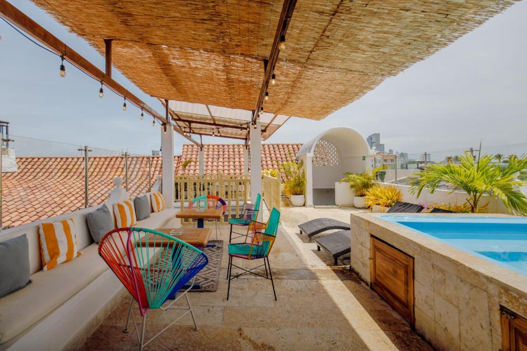 a patio with a table and chairs and a swimming pool at La Dominica Hotel Boutique in Cartagena de Indias